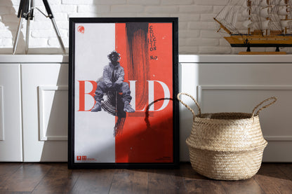 Framed BOLD poster in orange, featuring a gritty mixed-media aesthetic and punk-inspired design, placed in a room with a basket and vintage sailor boat on a shelf.