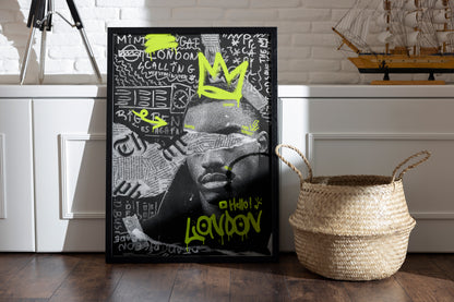 Framed Hello! London poster with a dynamic urban-British design, featuring graffiti crowns and iconic London phrases, placed in a room with a basket and vintage sailor boat on a shelf.