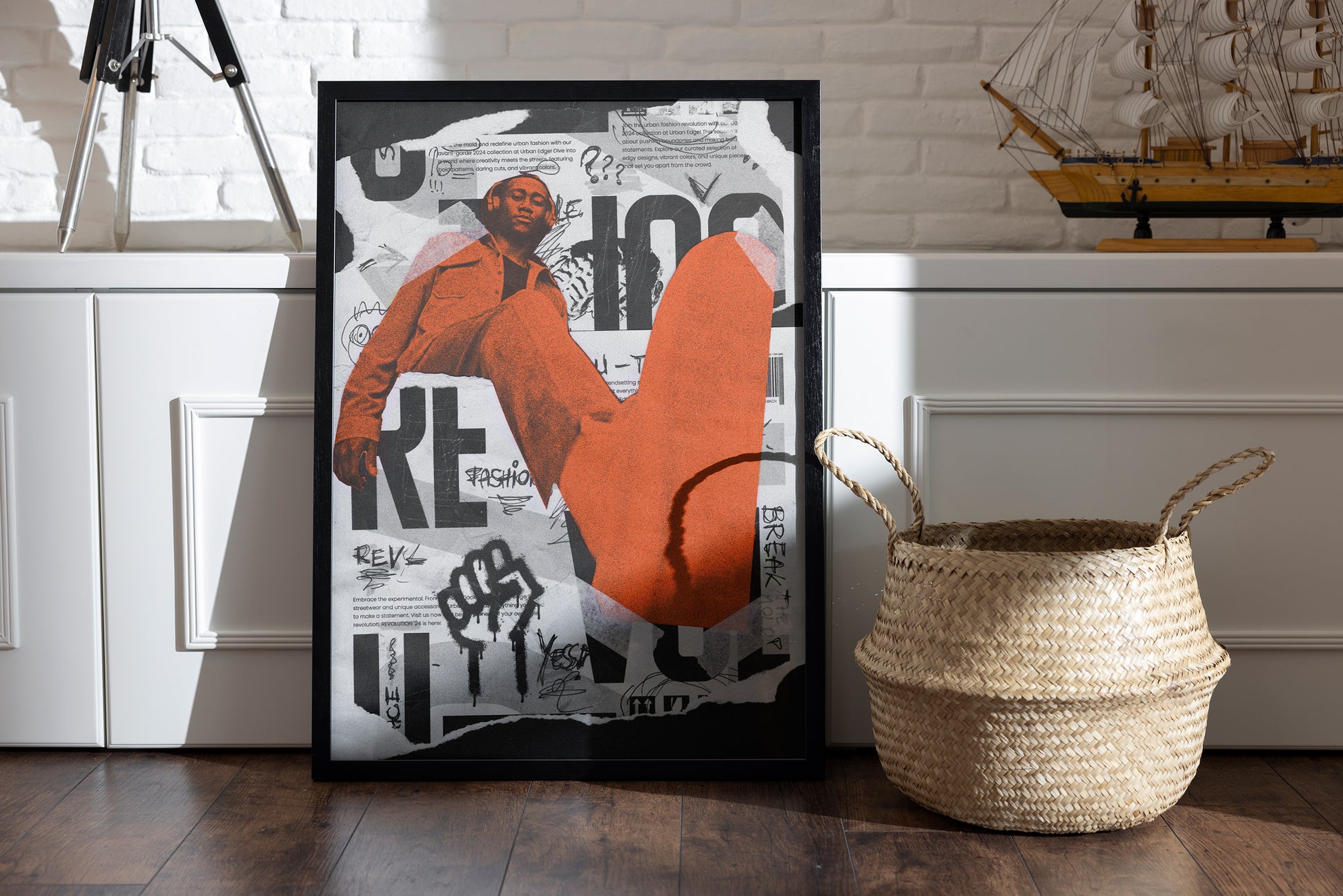 Revolution framed poster with torn-paper layers, bold visuals, and urban fashion themes, placed in a room with a basket and vintage sailor boat on a shelf.